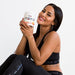 Smiling woman holding EHP Labs OxyShred Non-Stim for fat loss and energy boost