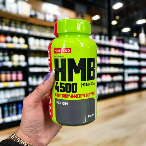 Close-up of (Nutrend HMB 4500 - 100 caps) held up inside My Supplement Shop, clearly showing the front label in a Sports Nutrition setting.